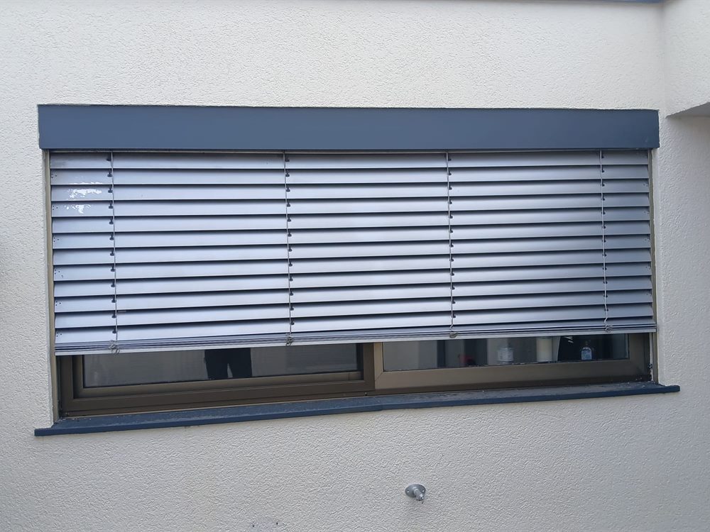 Außenraffstore mit verstellbaren Lamellen an einem Fenster